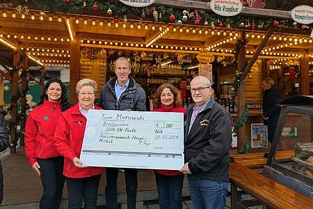 Spendenübergabe Herzenswunschmobil Auf dem Fürther Weihnachtsmarkt übergaben Ronald und Petra Morawski (rechts) den Spendenscheck über 3000 Euro an Andrea Engelhardt (l.) und Waltraud Heiter (2.v.l.), die sich beide ehrenamtlich beim Herzenswunschmobil engagieren, sowie BRK-Kresigeschäftsführer Thomas Leipold (Mitte).